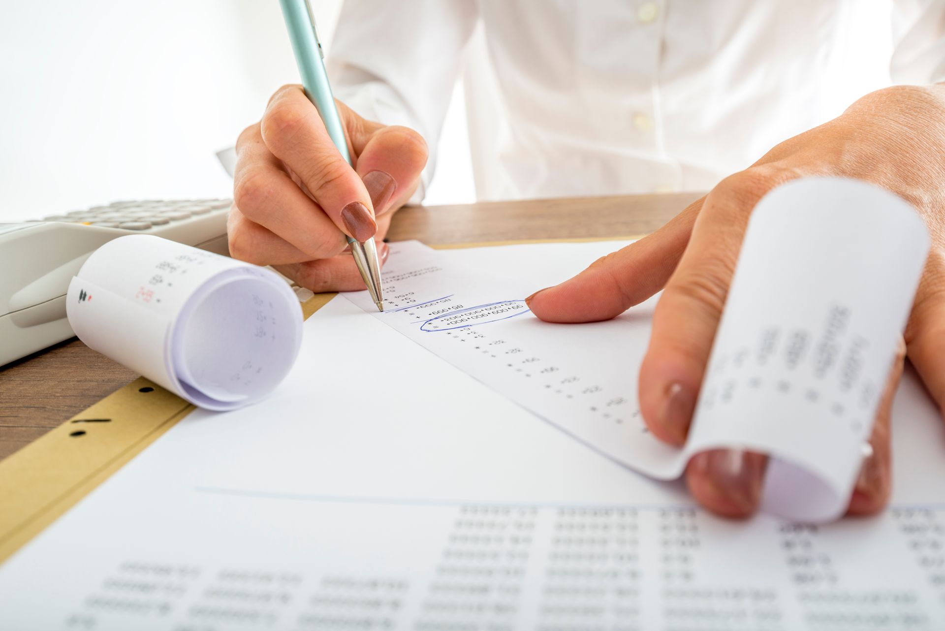 A person is writing on a piece of paper with a pen.