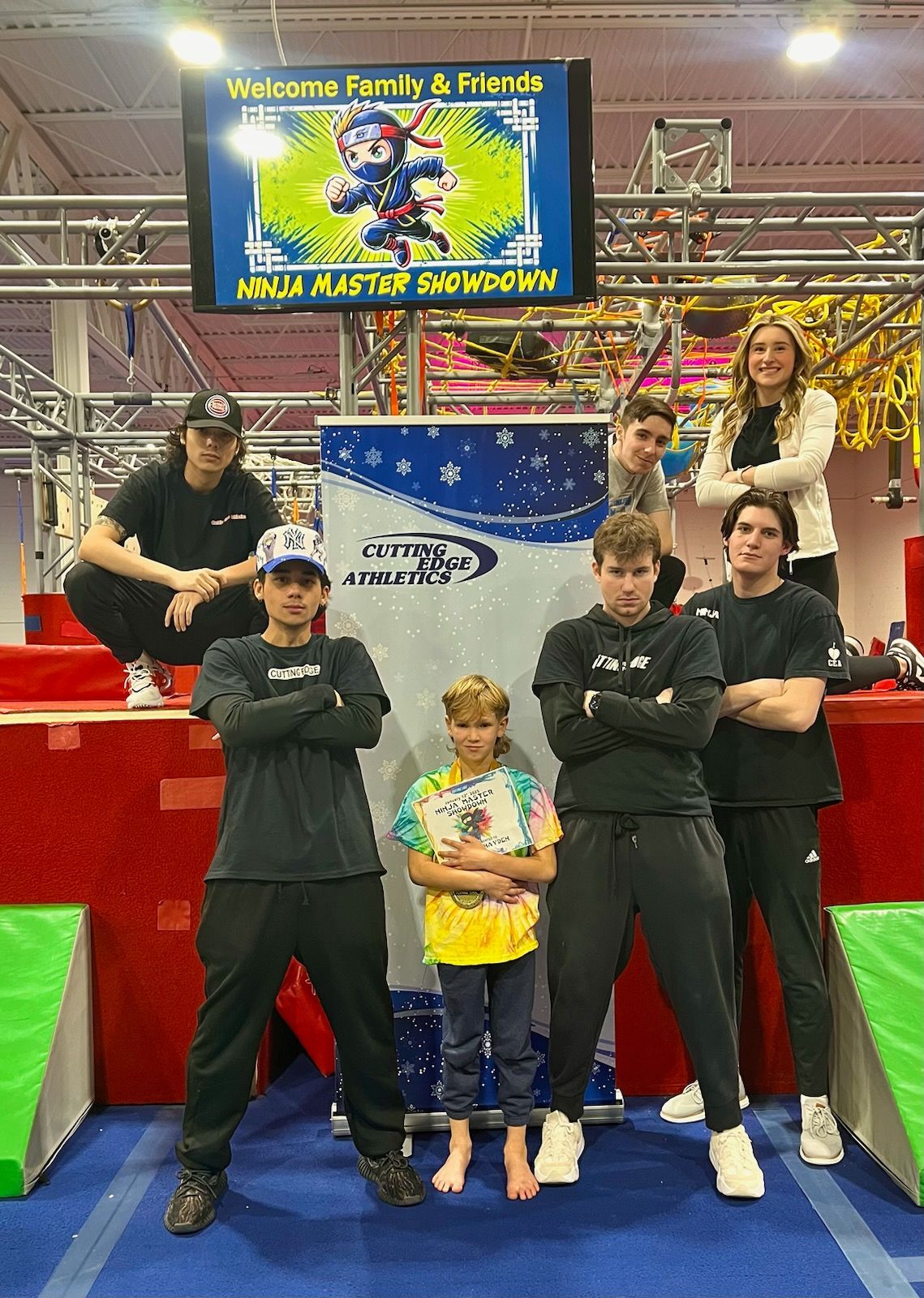 A group of people are posing for a picture in a gym.
