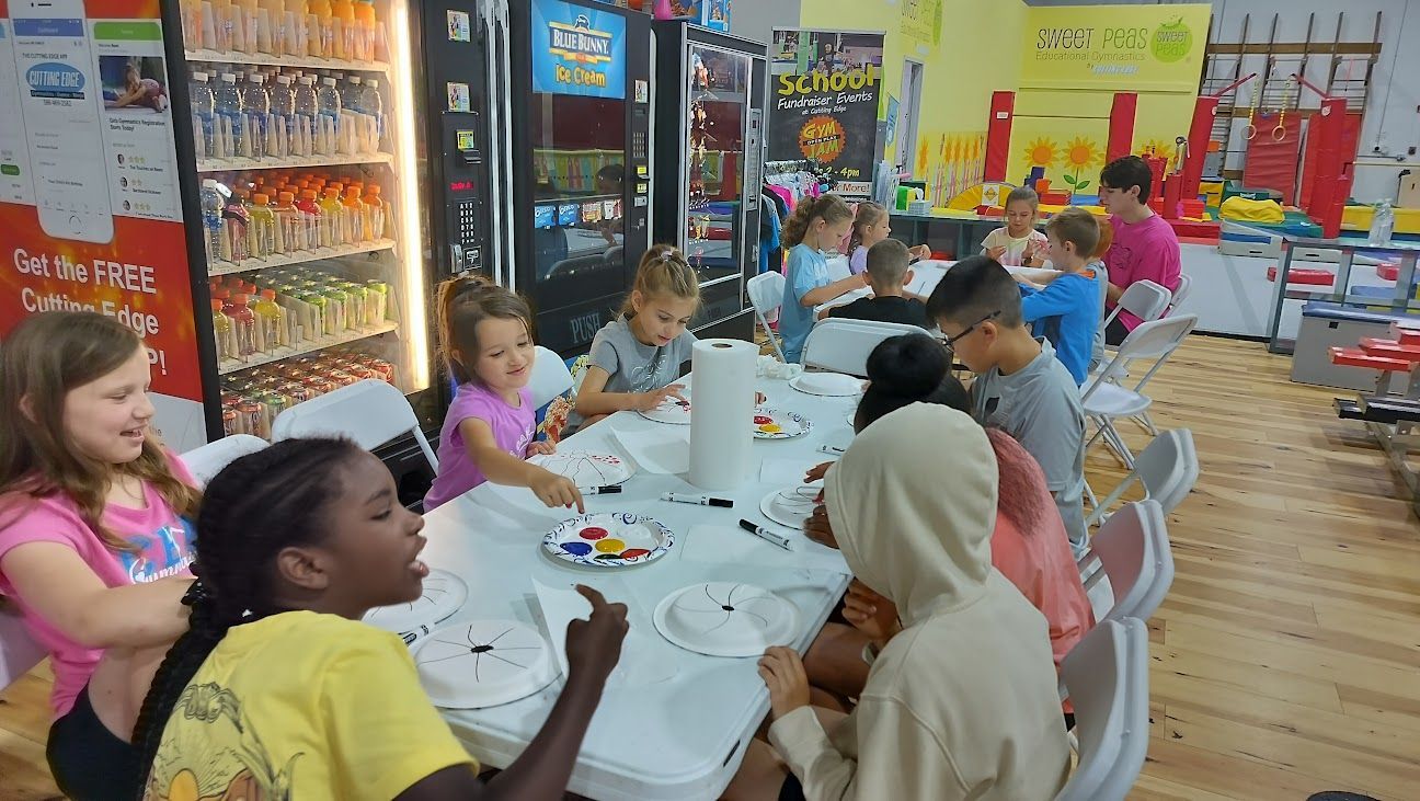 A group of children are sitting at a table in a room.