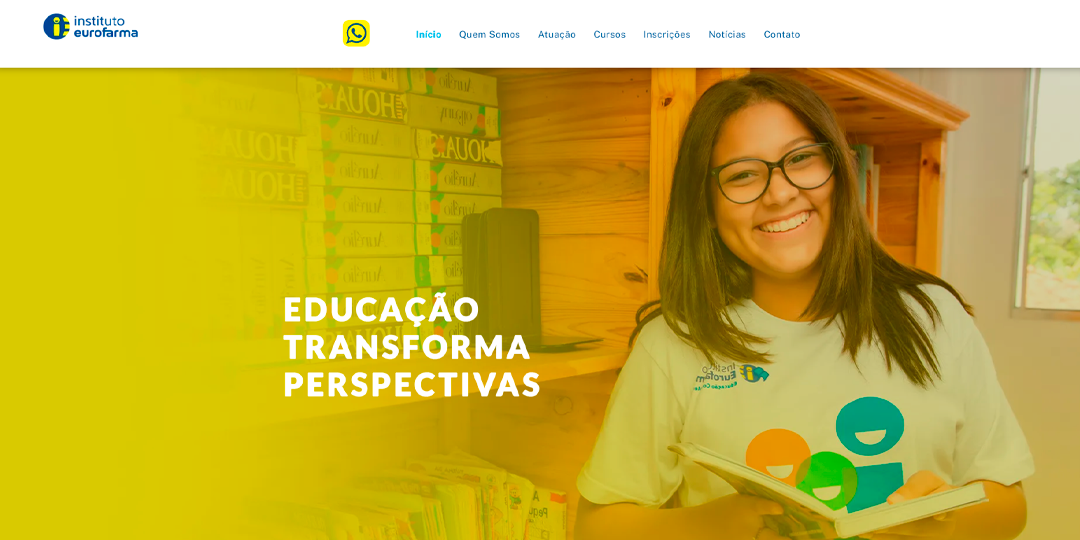 Uma mulher de óculos está segurando um livro e sorrindo.