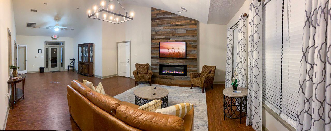 Living room with a fireplace, TV, seating, and windows.