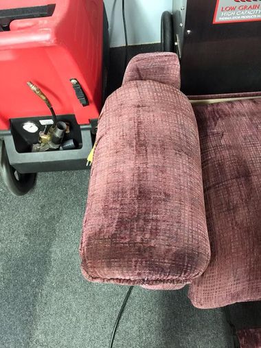 Purple armrest and seat beside a red machine in a vehicle interior
