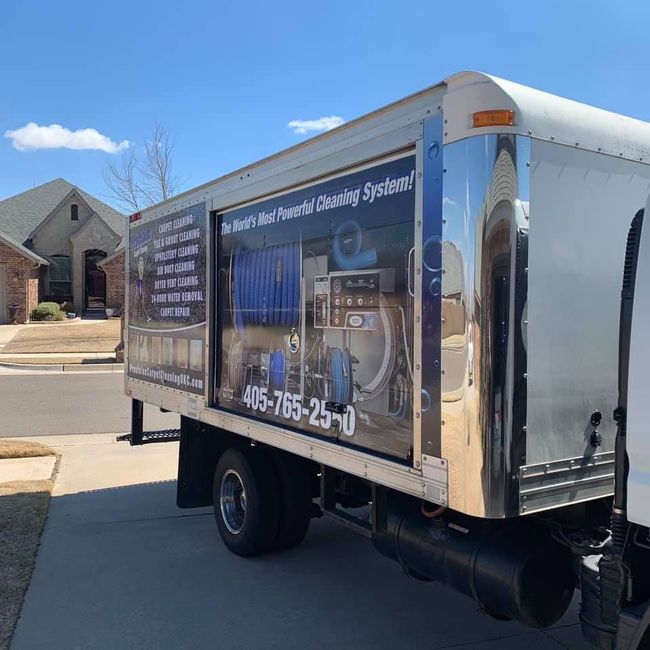 Chrome box truck with plumbing service ad parked on a suburban street