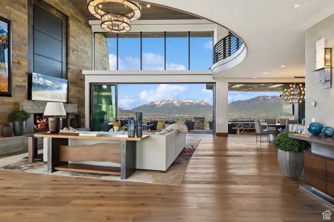 Modern living room with mountain views, wood floors, large windows, and contemporary furnishings
