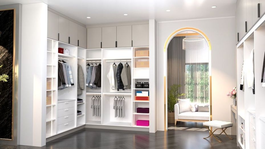 Bright modern walk-in closet with white shelving, hanging clothes, and an arched doorway to a sunlit room