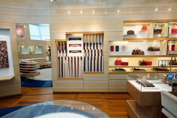 Modern retail display with clothing shelves, wall-mounted accessories, and a polished wood floor