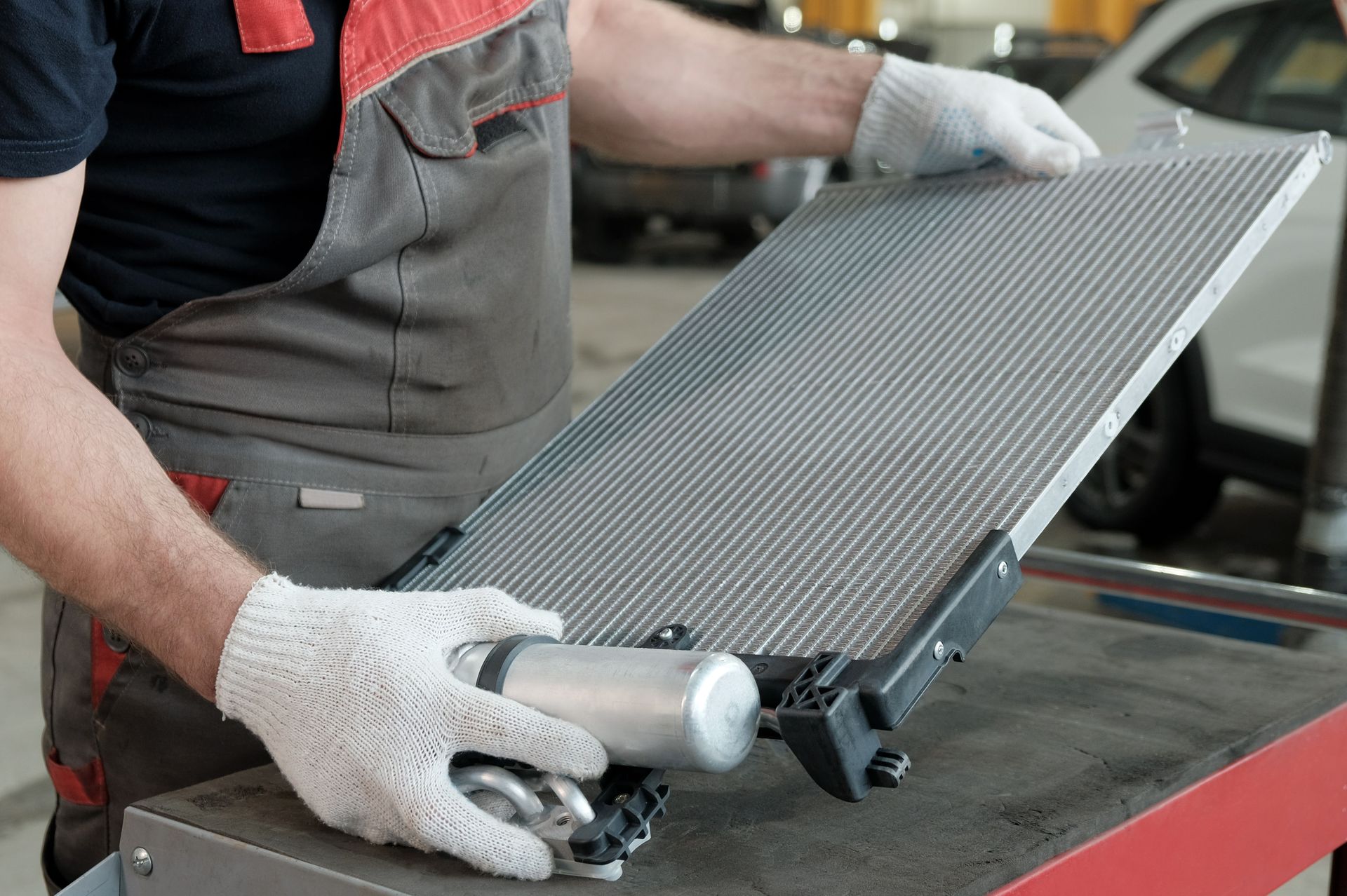 A man is working on a radiator in a garage.