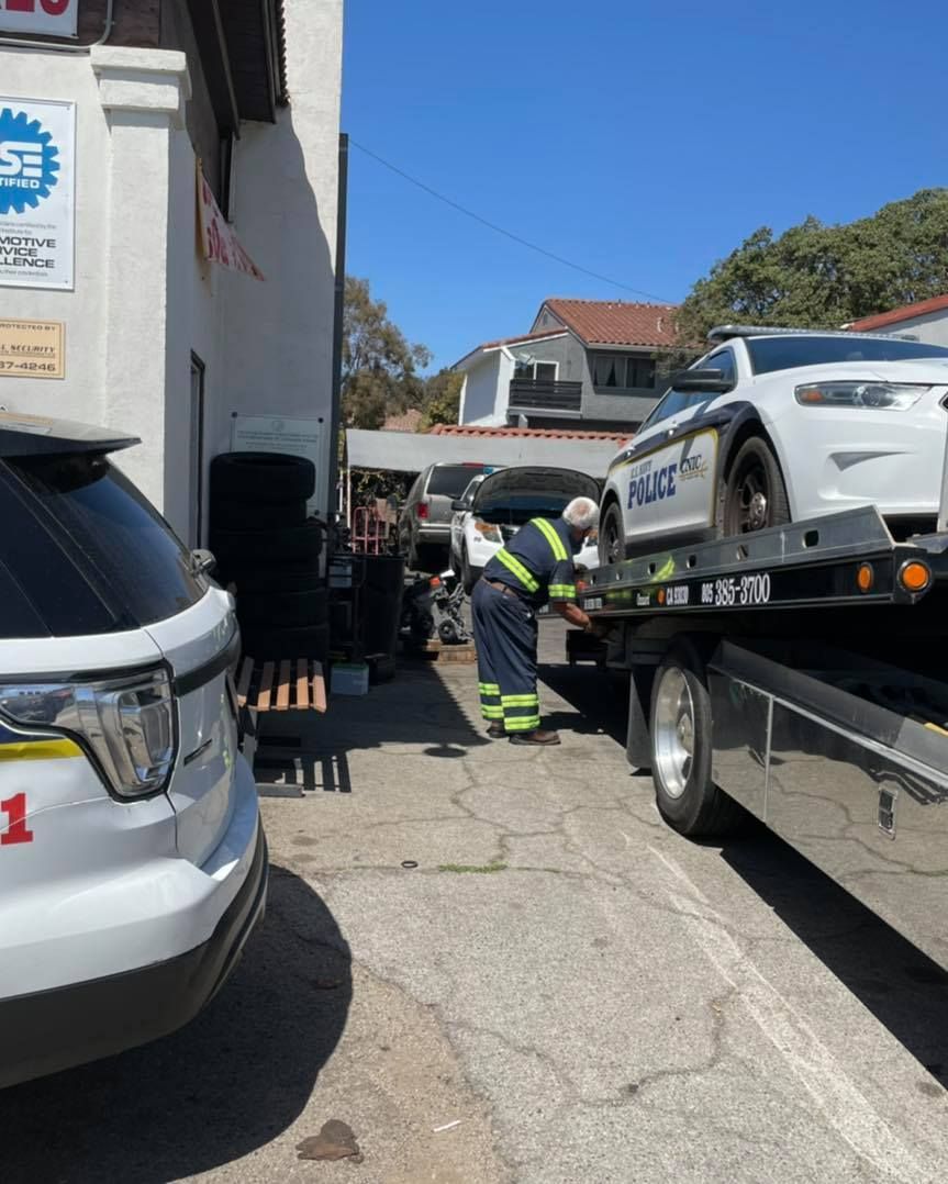 A police car is being towed by a tow truck.