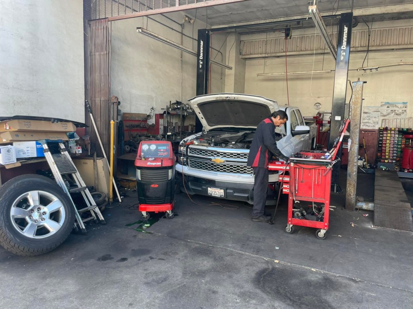A man is working on a truck in a garage.