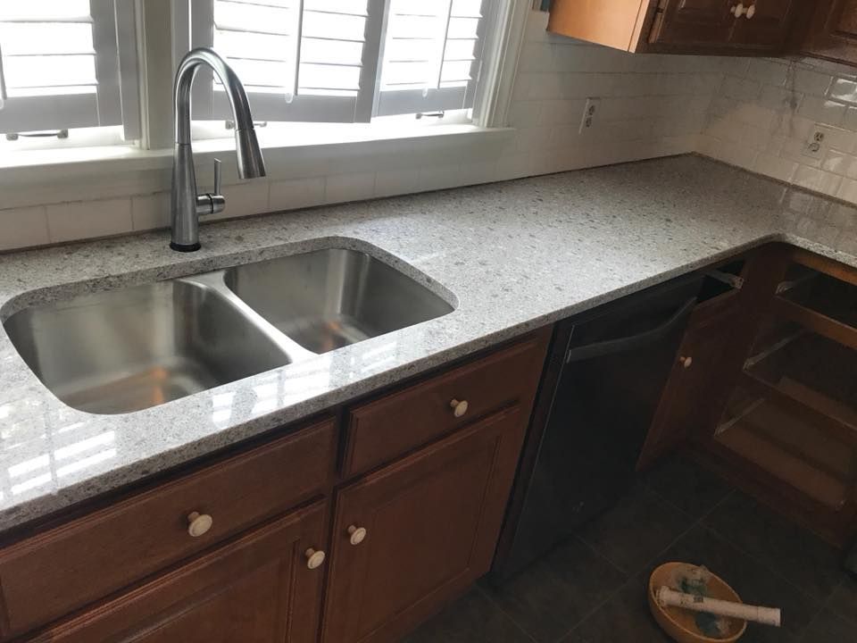 A kitchen with a stainless steel sink and a faucet.