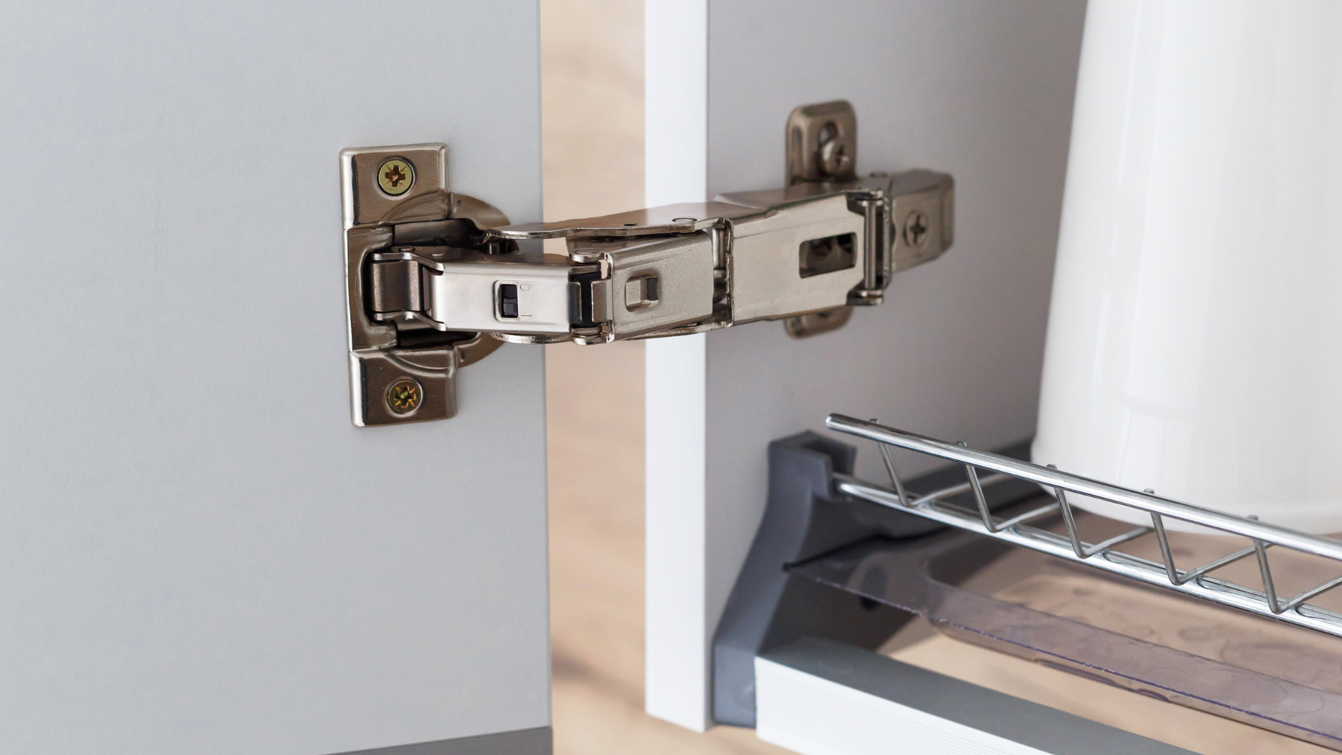 A close up of a cabinet door with a hinge on it.