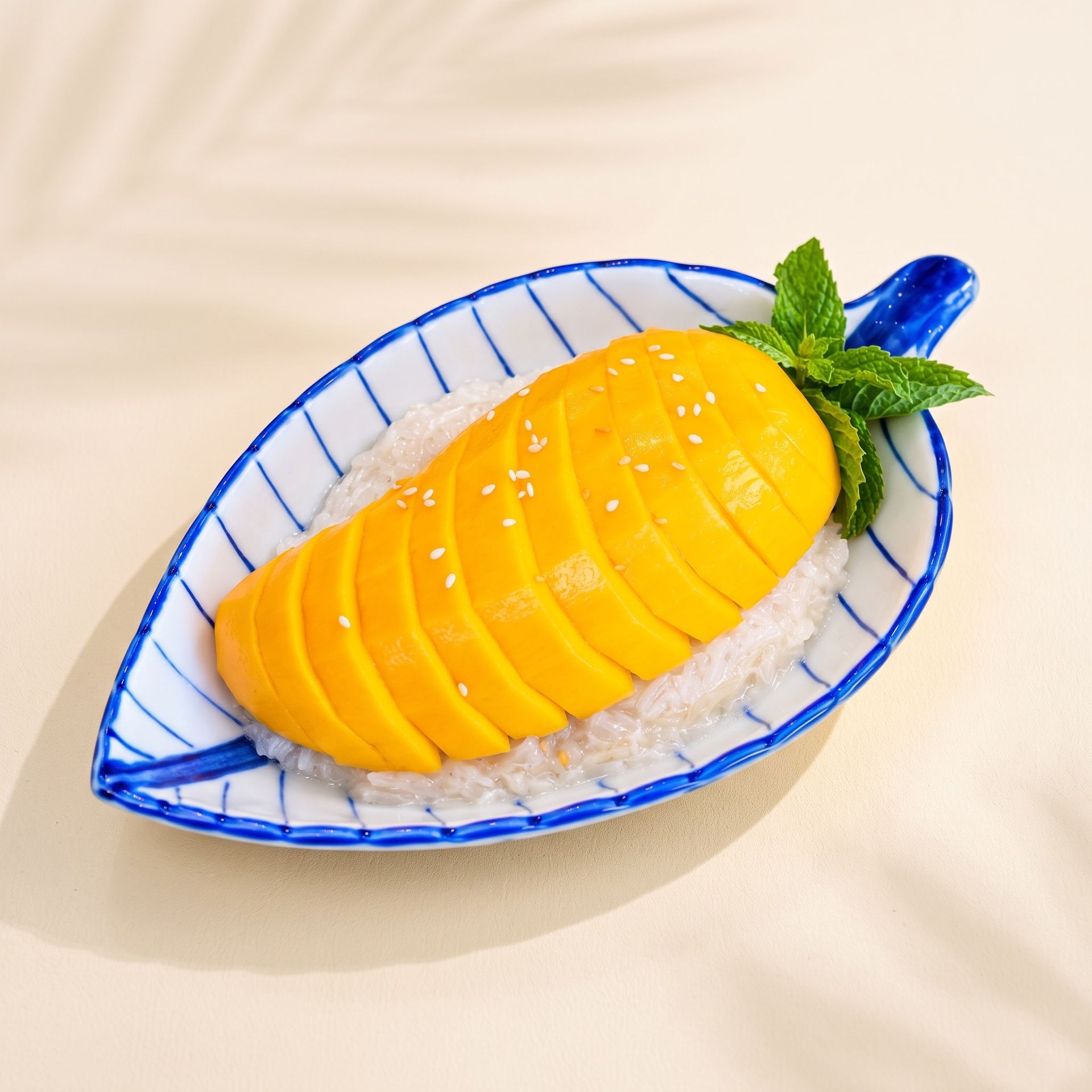 Sliced mango on a decorative blue-and-white plate