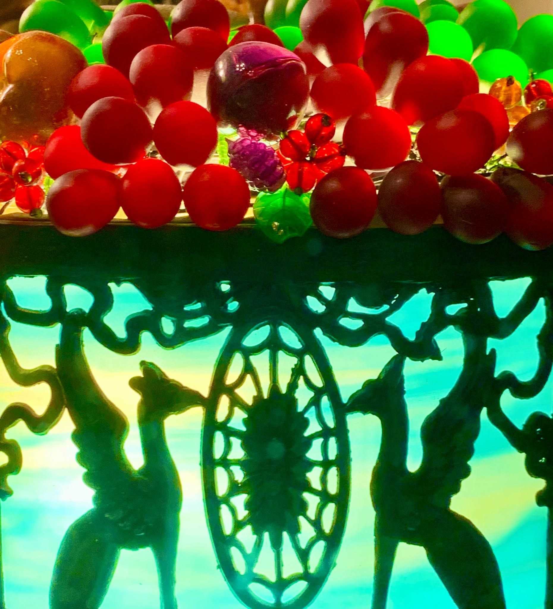 Colorful red and green balls over silhouetted dancers and ornate central design against a bright cyan background