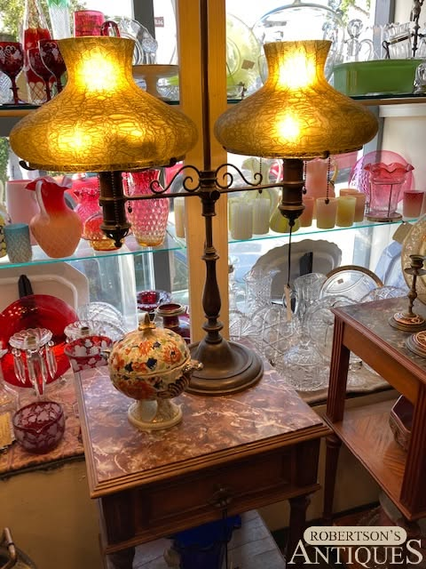 Antique table lamp with two amber glass shades on a marble base in an antiques shop