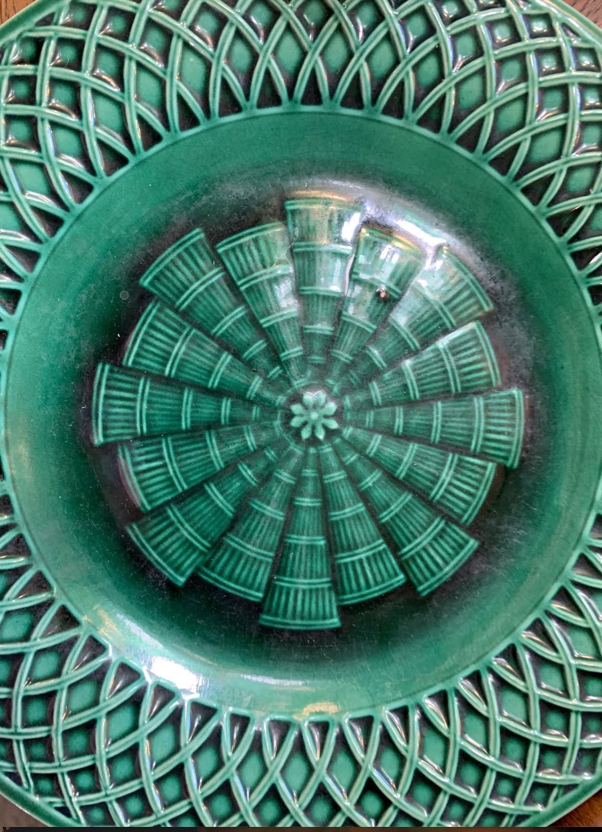 Green decorative circular pattern with a geometric lattice and concentric rings.