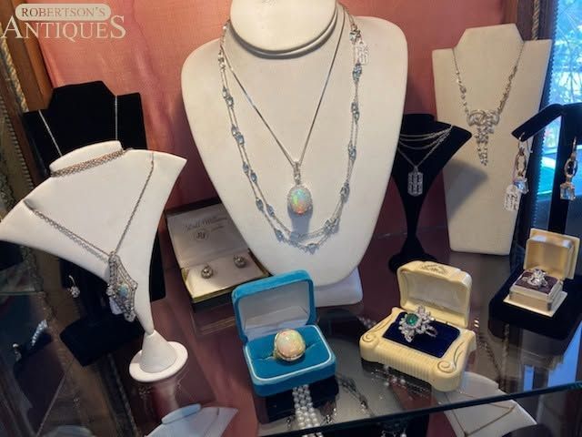 Jewelry display with silver necklaces and gemstone pendants on white and black bust stands