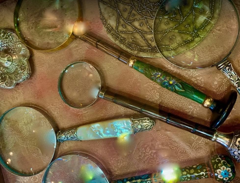 Decorative glass wands with magnifying lenses, shimmering in iridescent colors on a textured surface