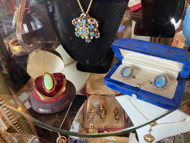 Jewelry display with necklaces, rings, earrings, and bracelets in red, blue, and gold cases