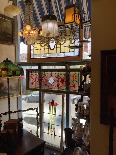 Stained-glass lamps and hanging lanterns in a shop window above a street view