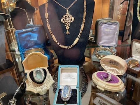 Jewelry store display with necklace busts, rings, and bracelets in gold, silver, and purple tones