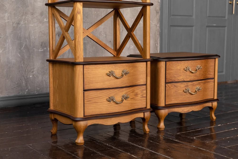 Two wooden nightstands with drawers and open lattice shelves on a dark floor