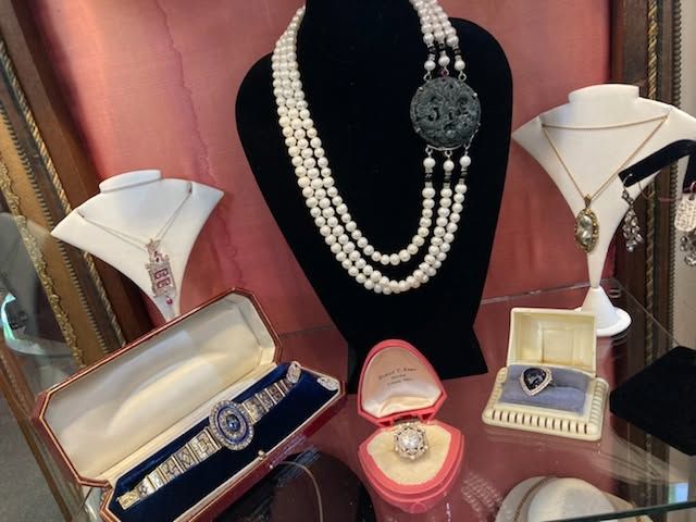 Jewelry display with necklaces, rings, and bracelet sets on velvet stands and boxes