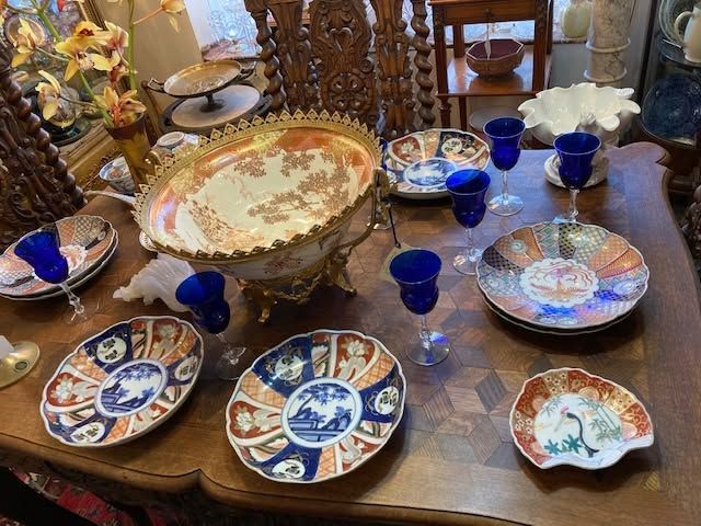 Antique blue and white porcelain dishes and cups arranged on a wooden table