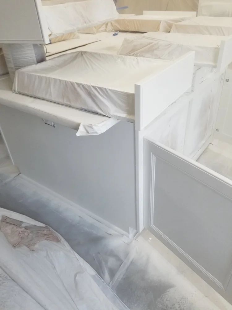 White painted furniture pieces wrapped in plastic, ready for shipment or storage.