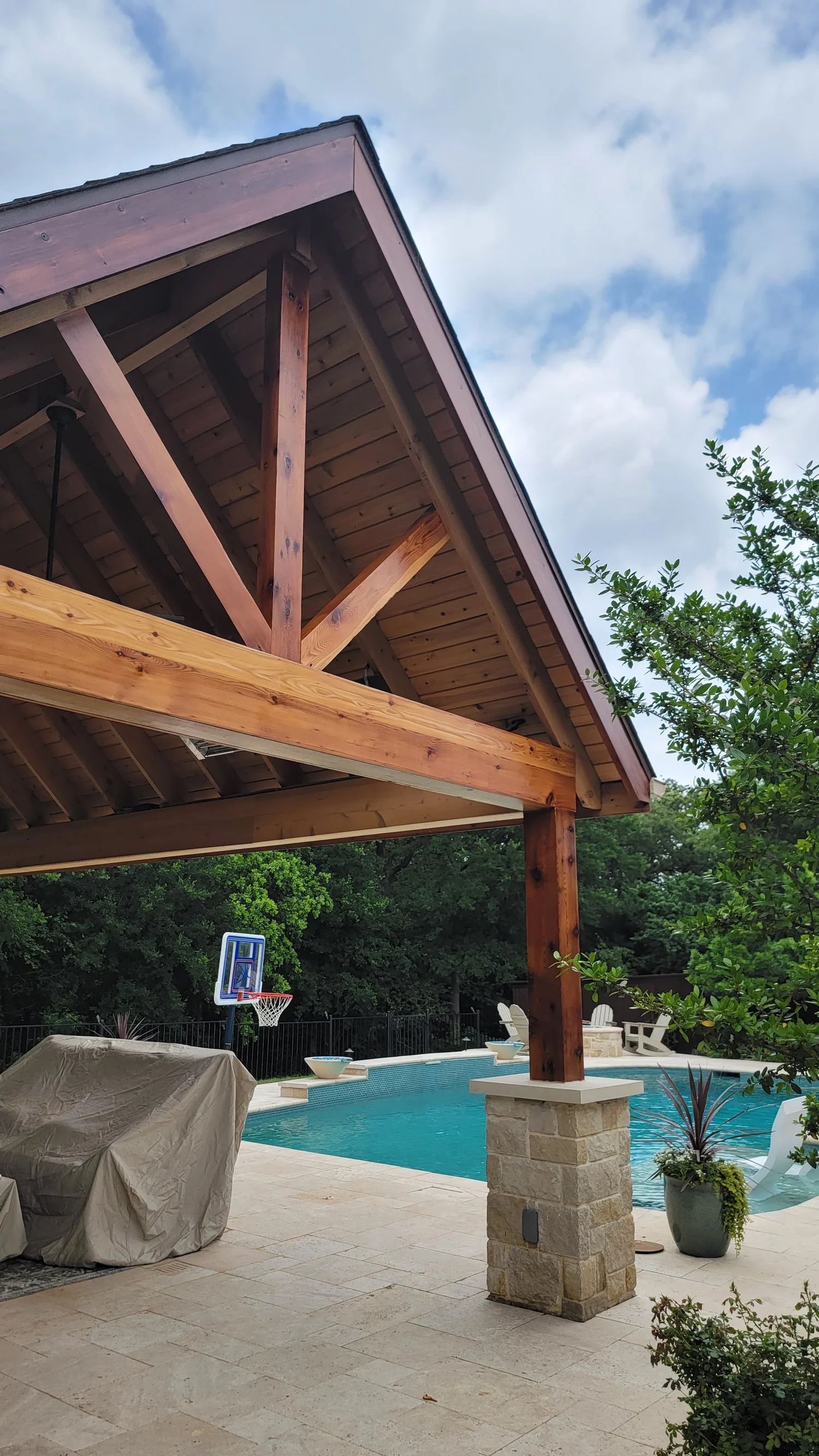 Wooden patio cover with pool in background.
