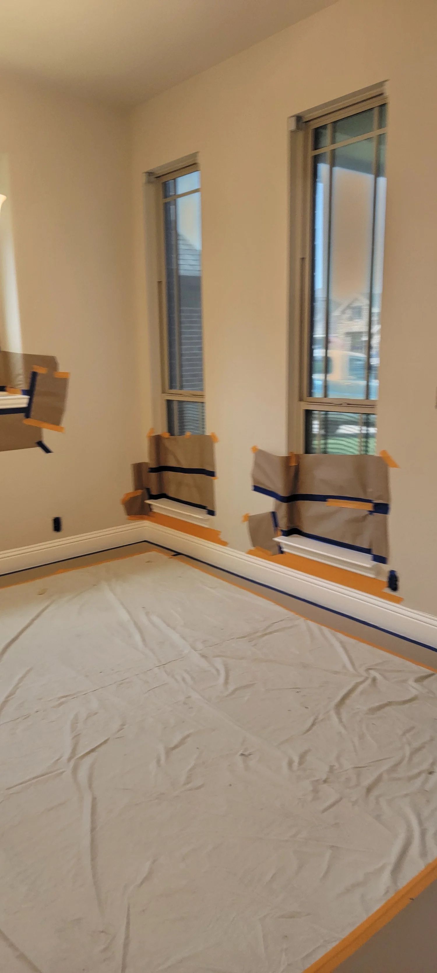 Room during construction; windows and floor are protected with paper and cloth.