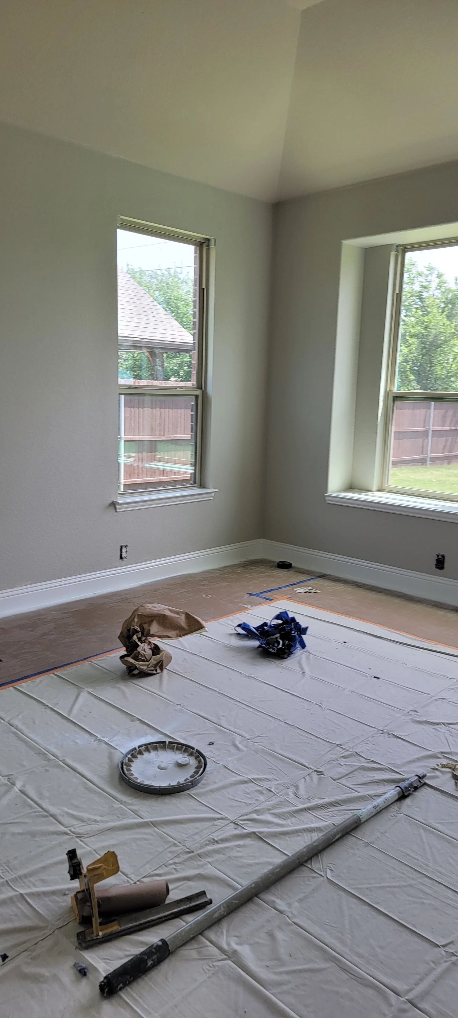 Interior room with paint supplies; windows, protective floor covering.