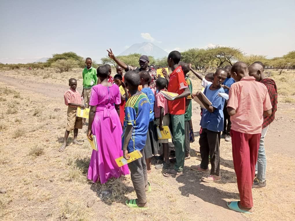 Makat village students standing in a group outside holding books.