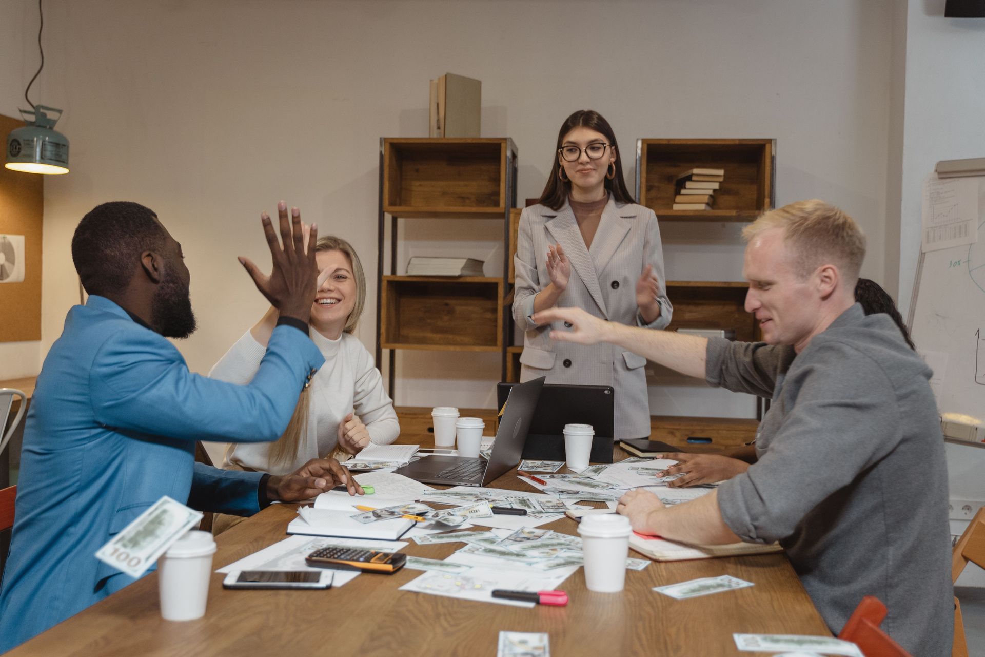 Equipe em reunião comemorando resultados, ilustrando a ordem entre avaliação, bônus e PDI