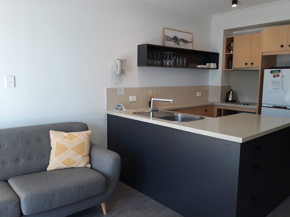 A Living Room With A Couch And A Kitchen — Cut N Edge Panel Factory In Coolum Beach, QLD