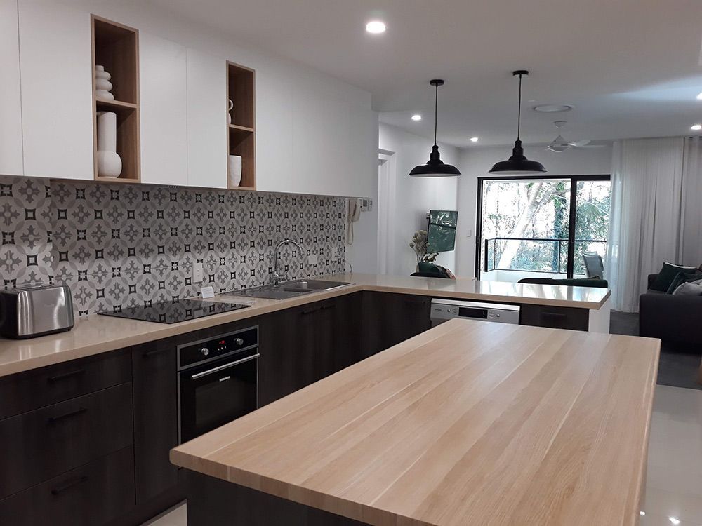 Modern kitchen with dark wood cabinets, patterned backsplash, and a light wood island. — Cut N Edge Panel Factory In Coolum Beach, QLD