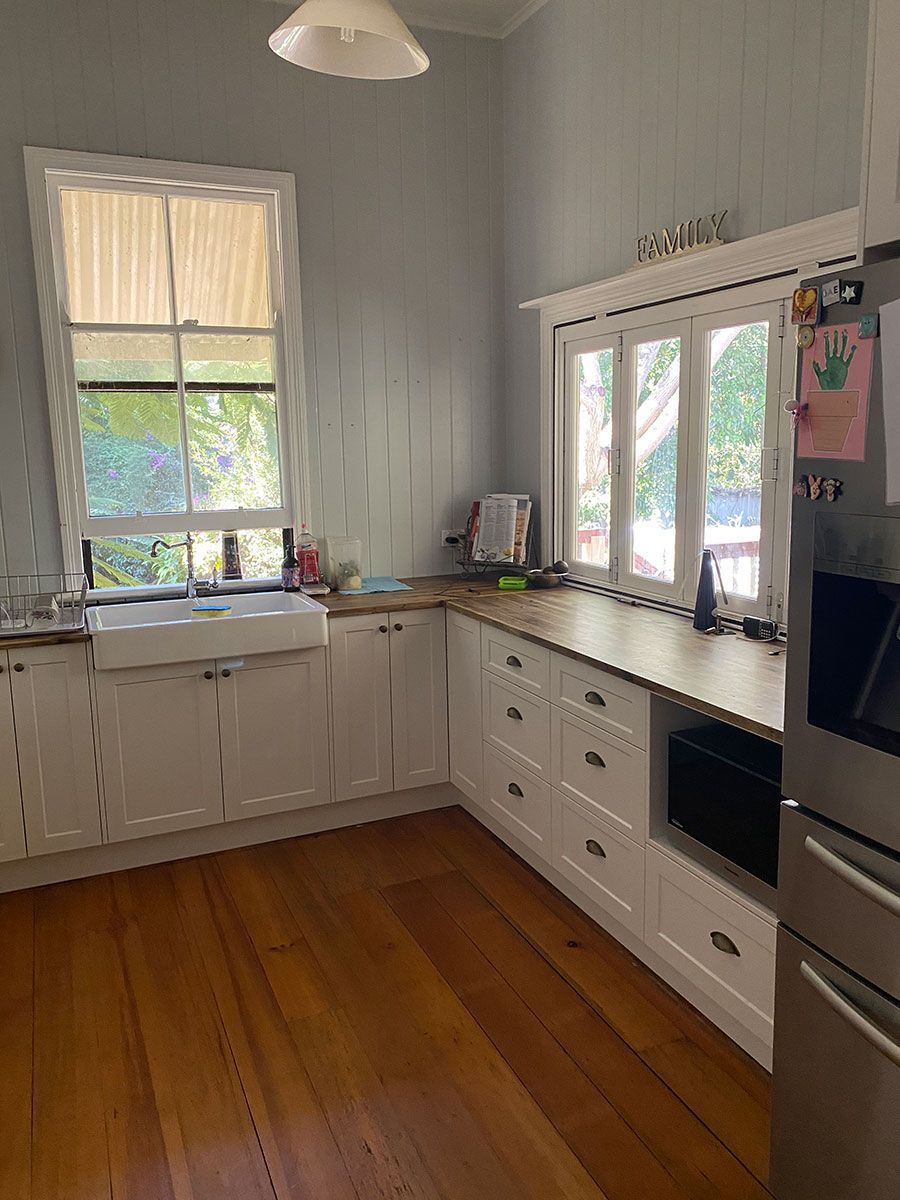 A Kitchen With Wooden Floors , White Cabinets — Cut N Edge Panel Factory In Coolum Beach, QLD