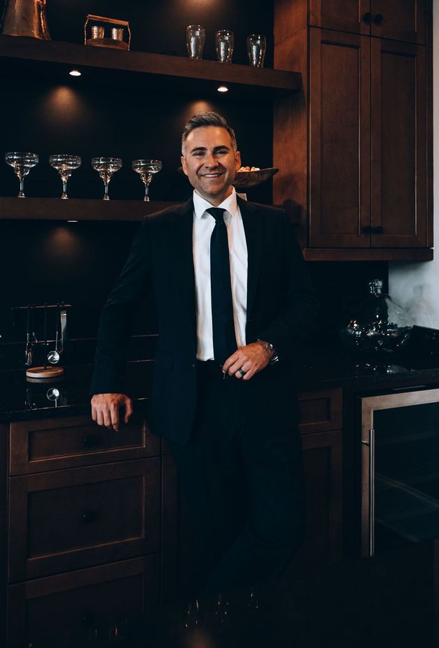 Joe Carteret n in a suit and tie is standing