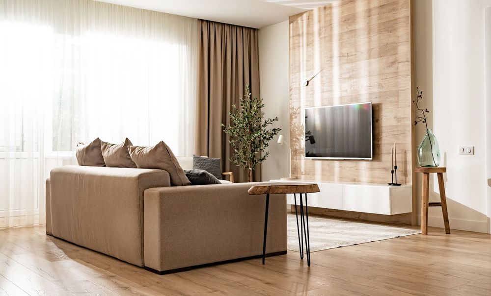 Living room with tan sofa, wood accent wall, and TV.