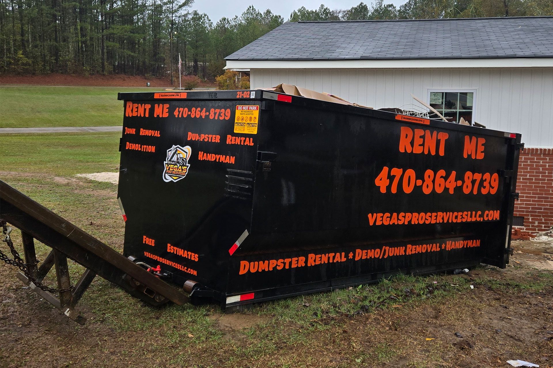 Black dumpster labeled
