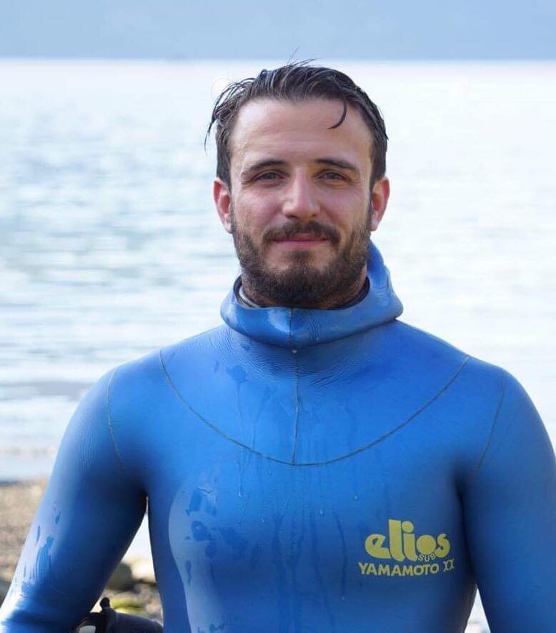 A man wearing a blue wetsuit that says elios on it