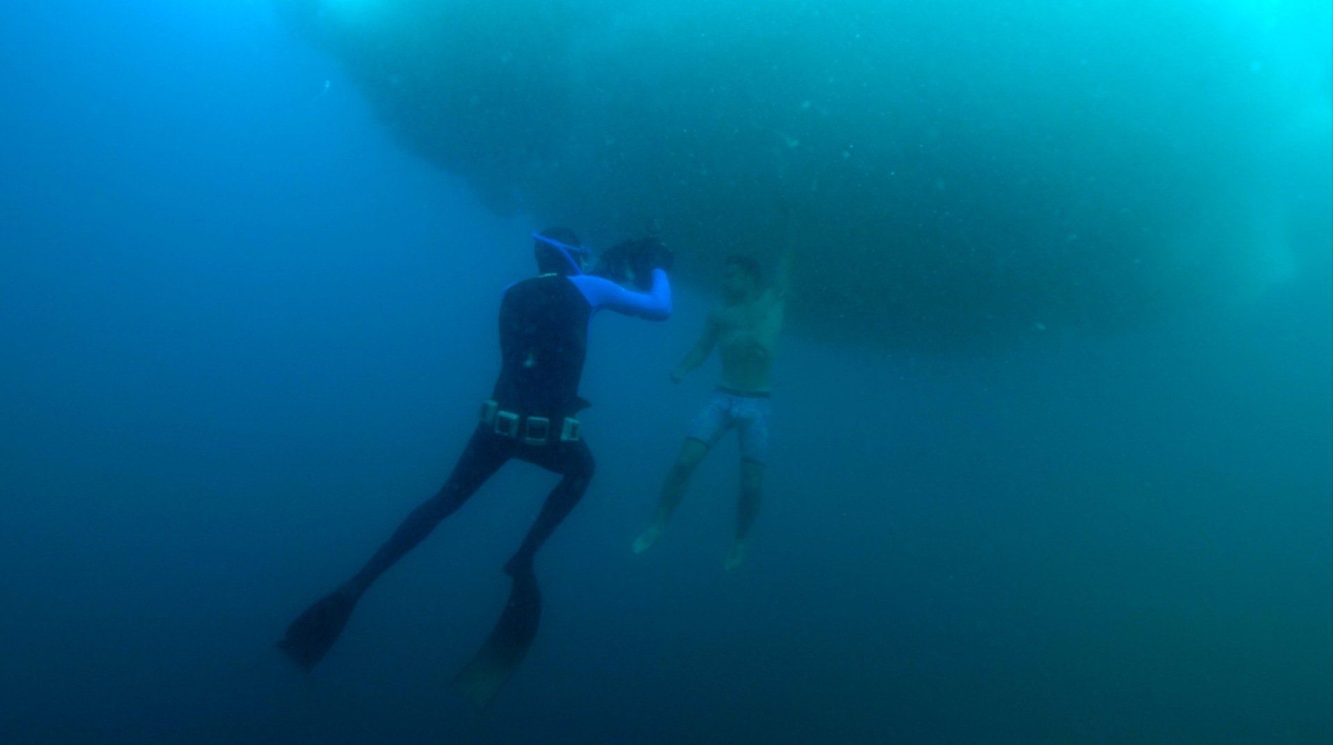A couple of people are swimming in the ocean.