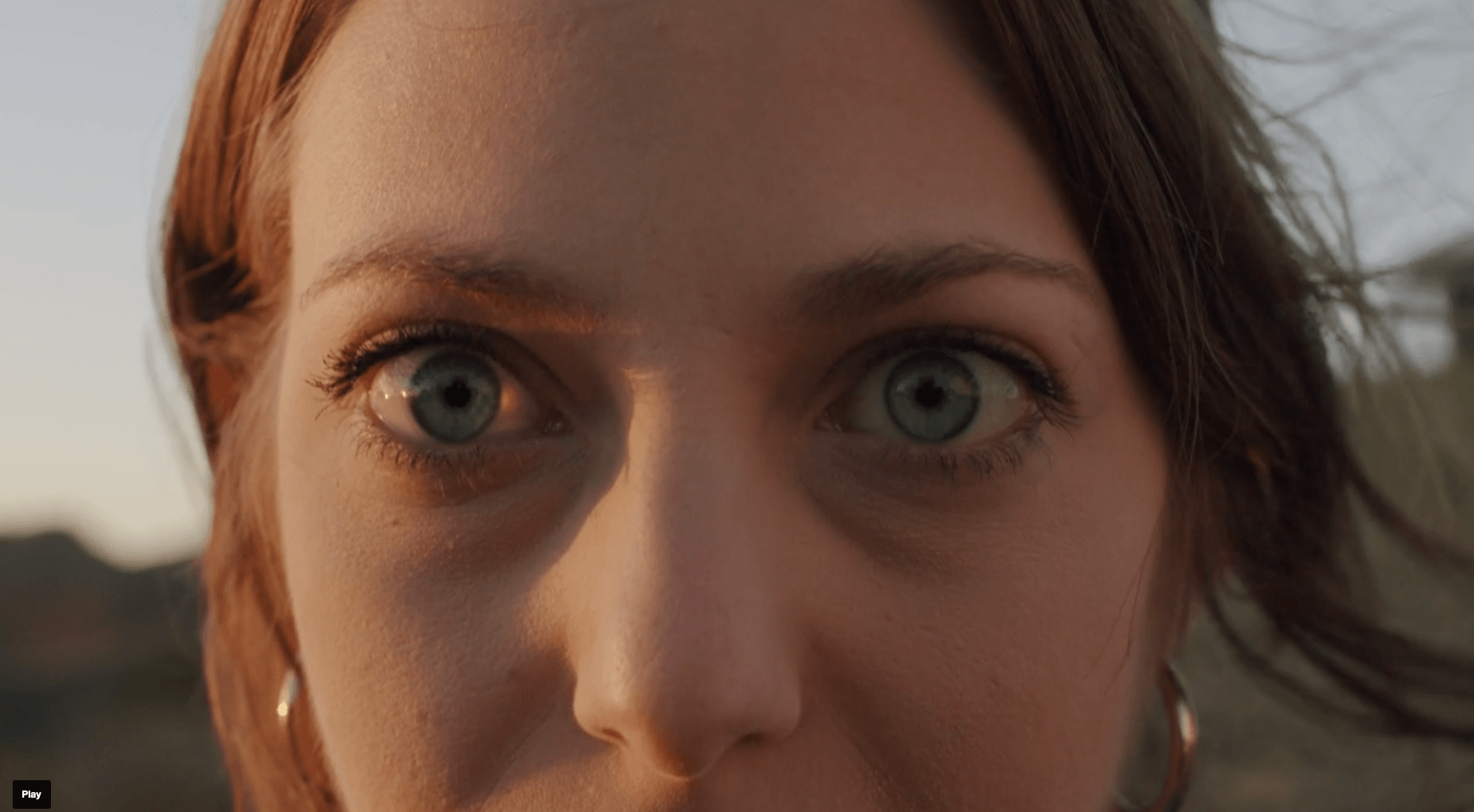 A close up of a woman 's face with blue eyes.