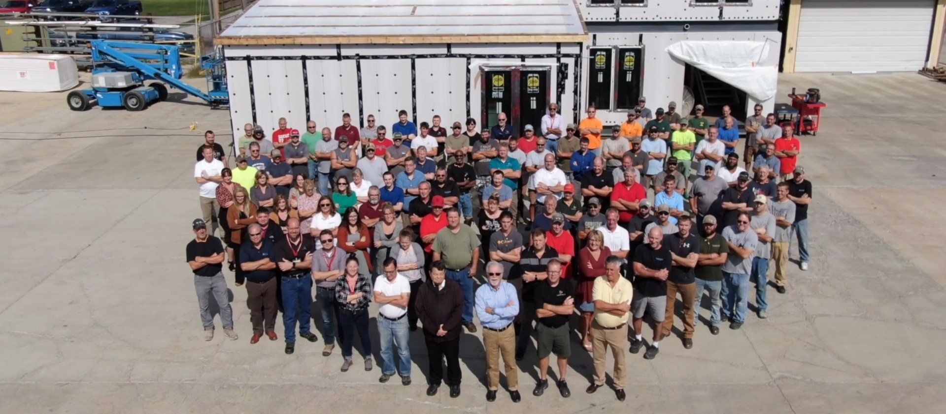 A large group of people are posing for a picture in front of a building.
