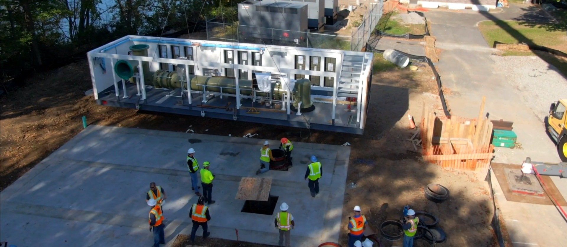 An aerial view of a construction site with workers moving a large structure.
