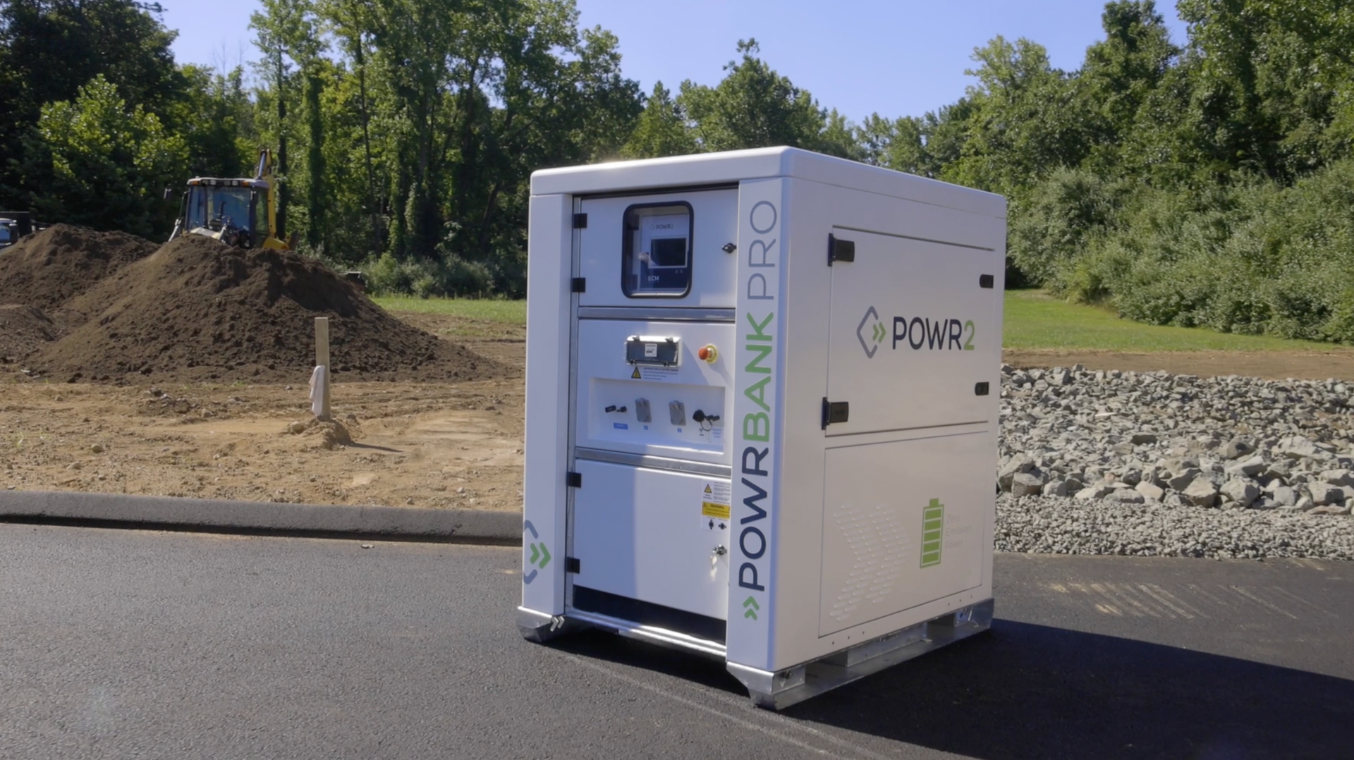 A white box is sitting on the side of a road next to a pile of dirt.