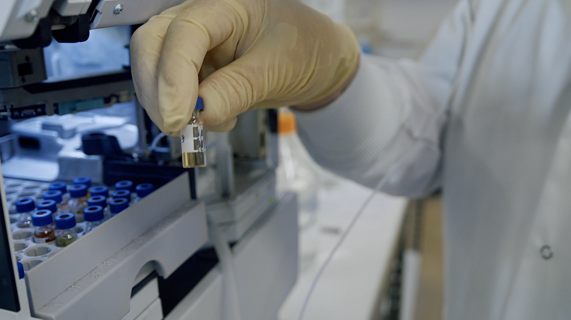 A person wearing gloves is holding a small object in their hand.