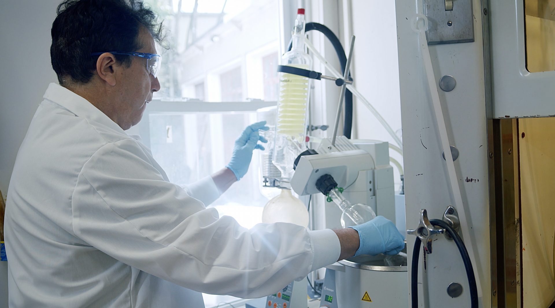 A man in a lab coat is working on a machine.