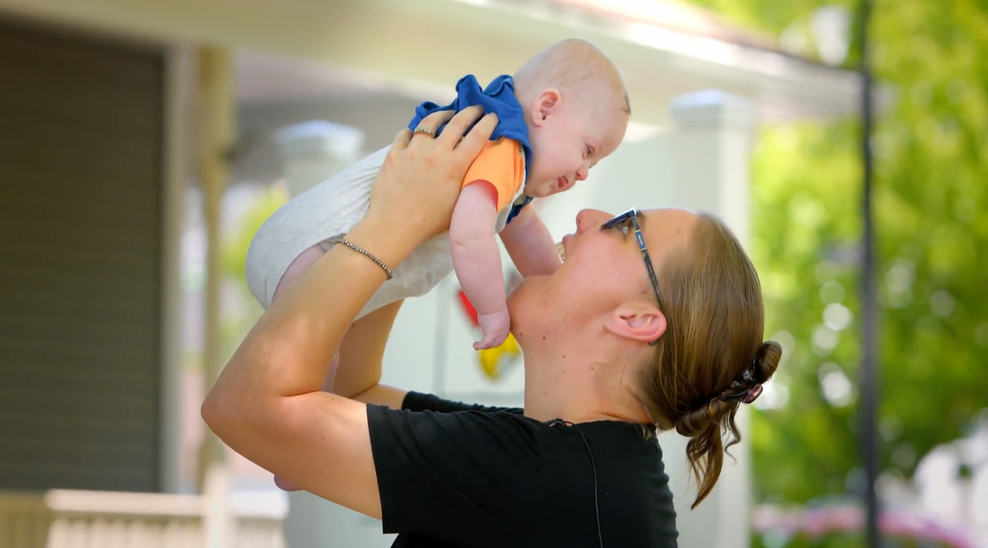 A woman is holding a baby in her arms.