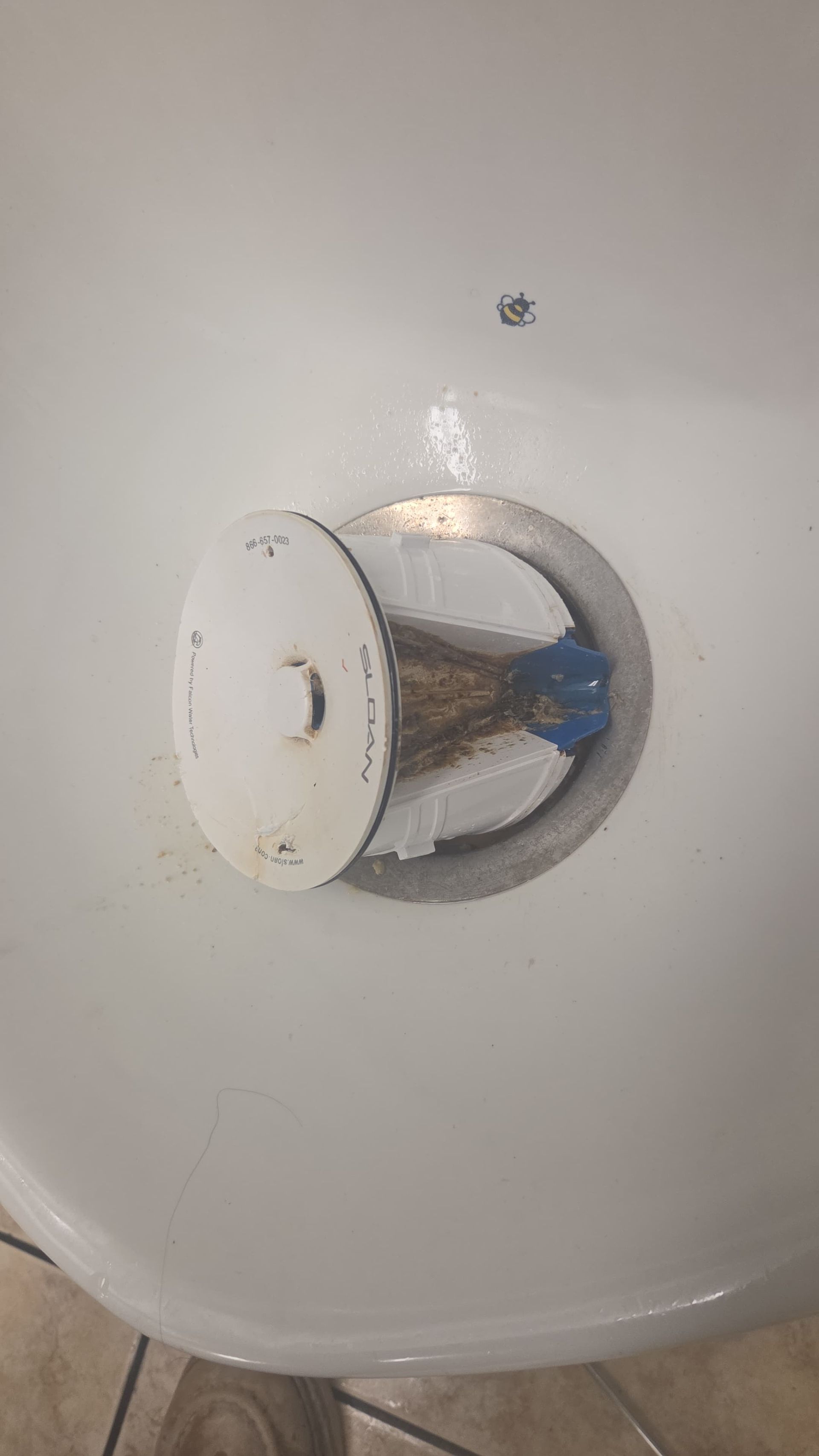 Chrome water valve knob on a white sink or basin.