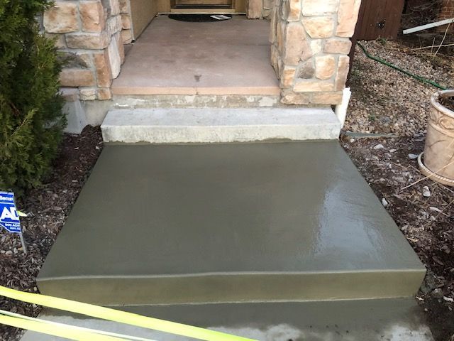 Freshly poured concrete ramp leading to a front porch entrance